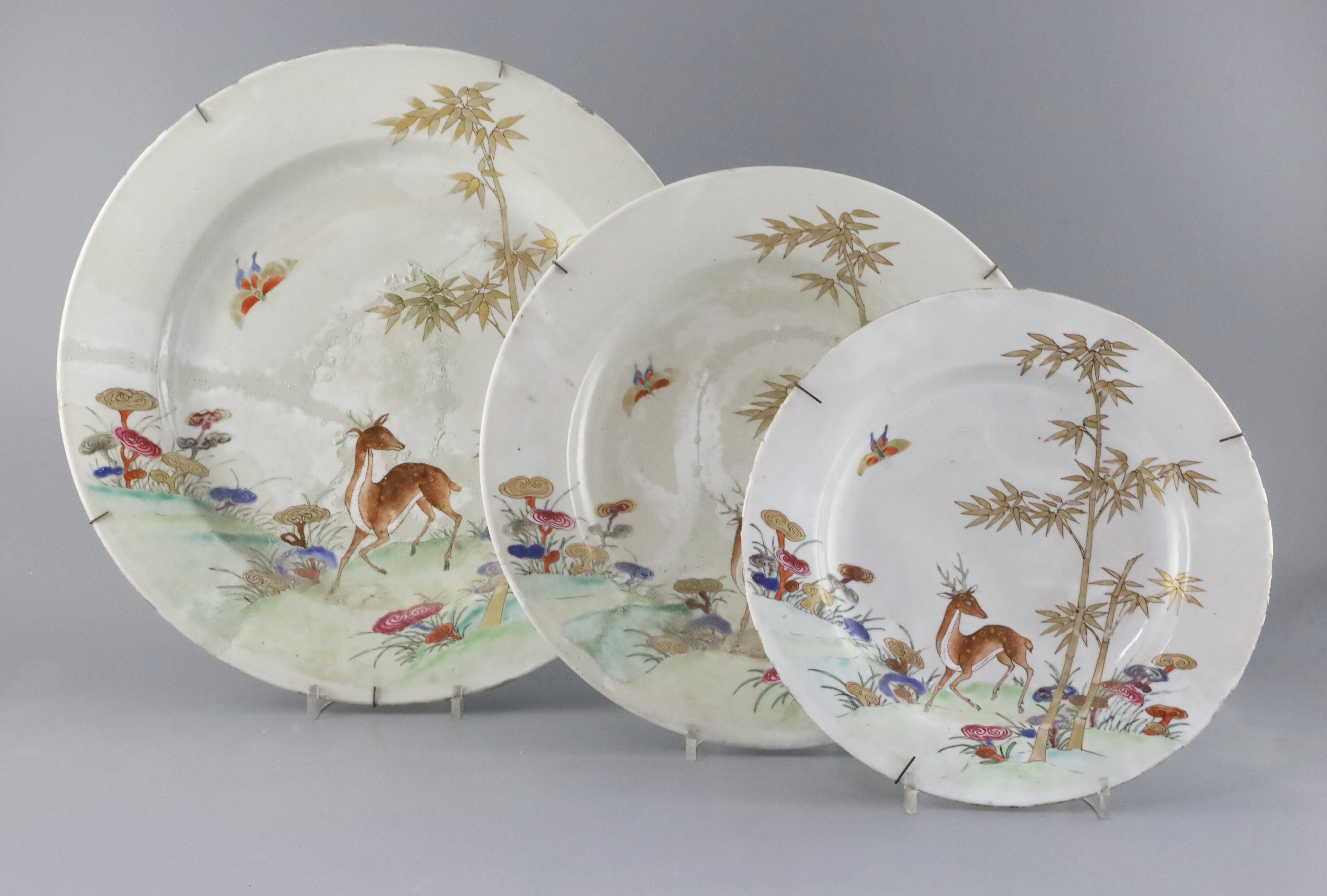 Three graduated Chinese famille rose deer, bamboo and lingzhi dishes, Qianlong period (1736-95), D. 26cm, 32cm and 38.5cm